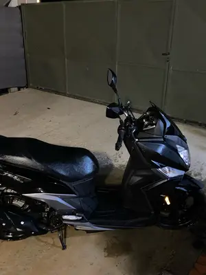 Scooter 50cc noir en très bon état général, avec rayure et rétroviseur cassé