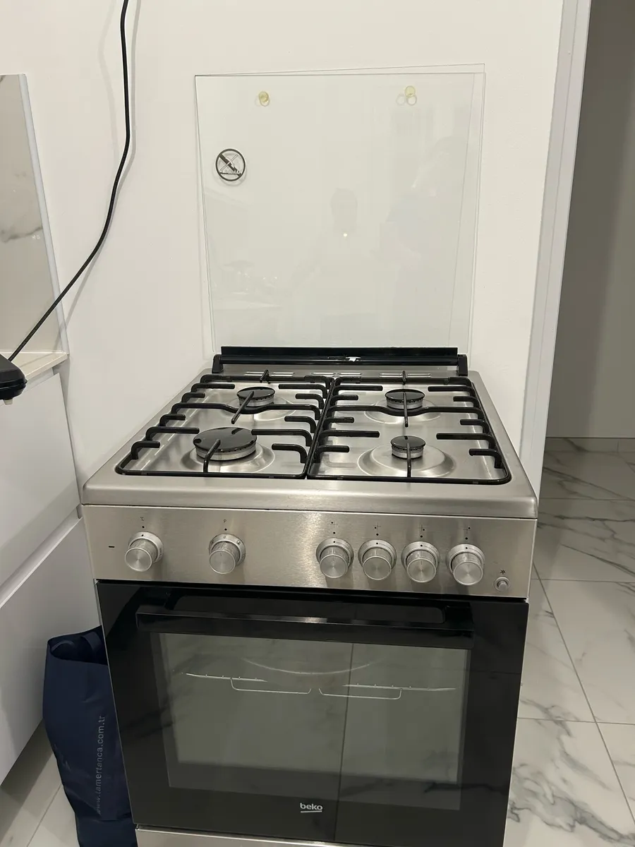 Cuisinière BEKO en inox avec 4 brûleurs à gaz et four à porte vitrée, comme neuve - Photo 1
