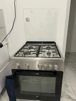 Cuisinière BEKO en inox avec 4 brûleurs à gaz et four à porte vitrée, comme neuve