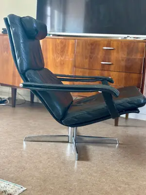 Fauteuil vintage scandinave en cuir noir pivotant, appui-tête et piètement chromé