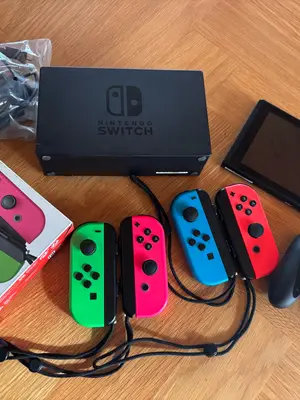 Nintendo Switch avec deux manettes, trois jeux et une manette Joy-Con